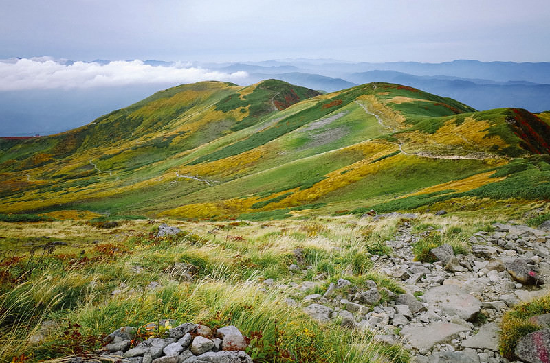 紅葉の月山のなだらかな登山道を歩む秋の稜線