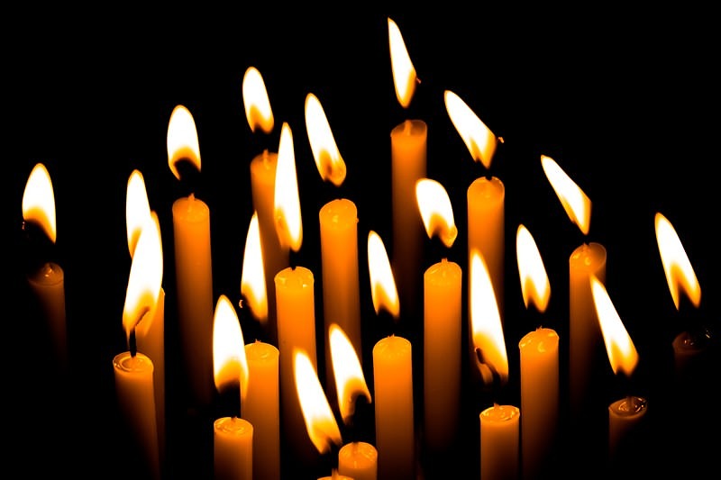 '暗闇に並ぶ複数の和蝋燭の灯り、揺らめく炎と光の陰影'