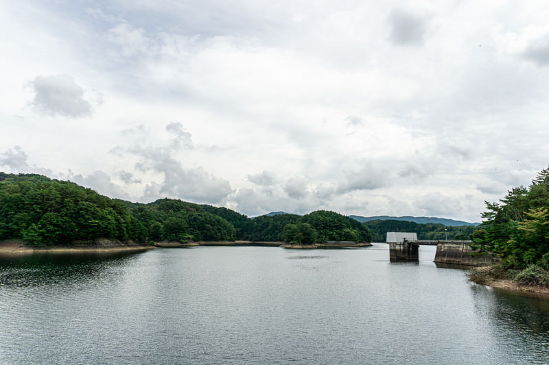 厚い雲に覆われた空の下に広がる黒田ダムによって作られた黒田湖