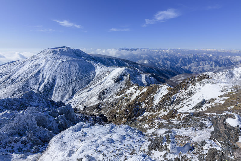 '冬の那須岳に雪化粧した成層火山の荒々しい山稜'