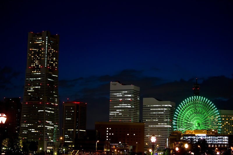 '緑にライトアップした観覧車が光るみなとみらいの夜景'