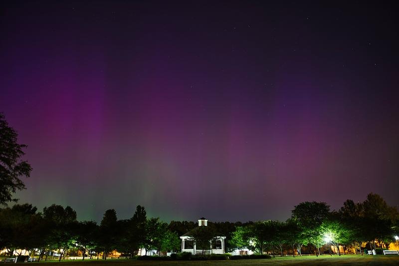 '夜空に広がる紫色のオーロラと公園のガゼボ'
