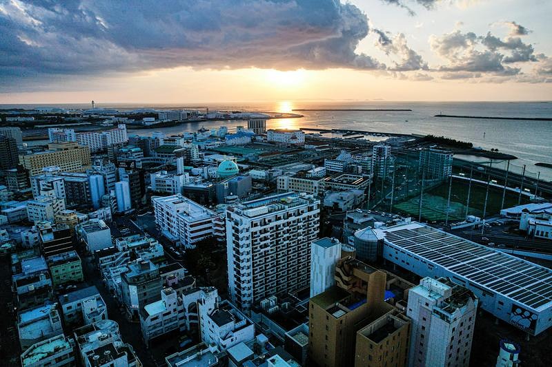 夕暮れの海沿いの街並みを見下ろす俯瞰風景