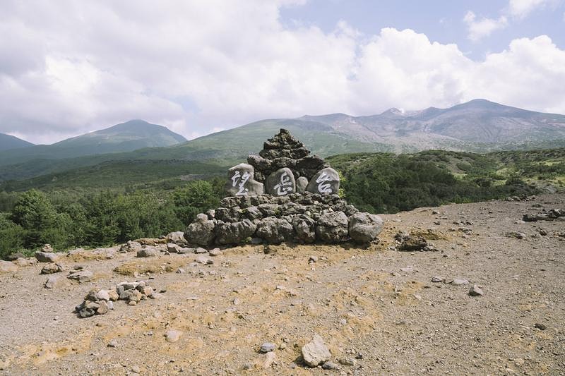 '十勝岳の絶景を望む登山口の石碑、北海道の日本百名山'