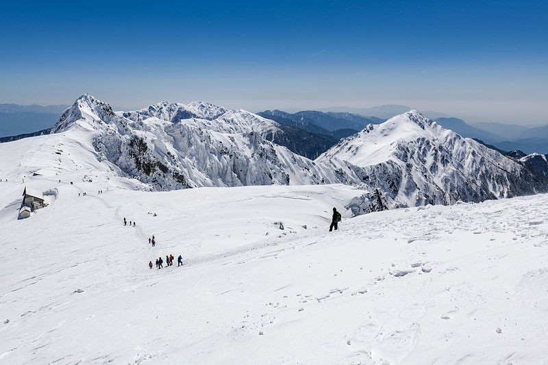 '冬の中央アルプスの雪原を歩く登山者たちの風景'