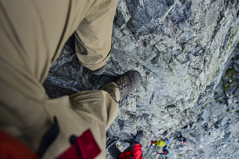 剱岳の小さな足場に足をのせる登山者
