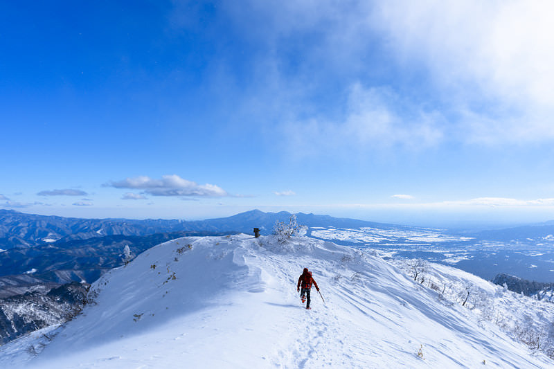 雪原で駆け出す登山者