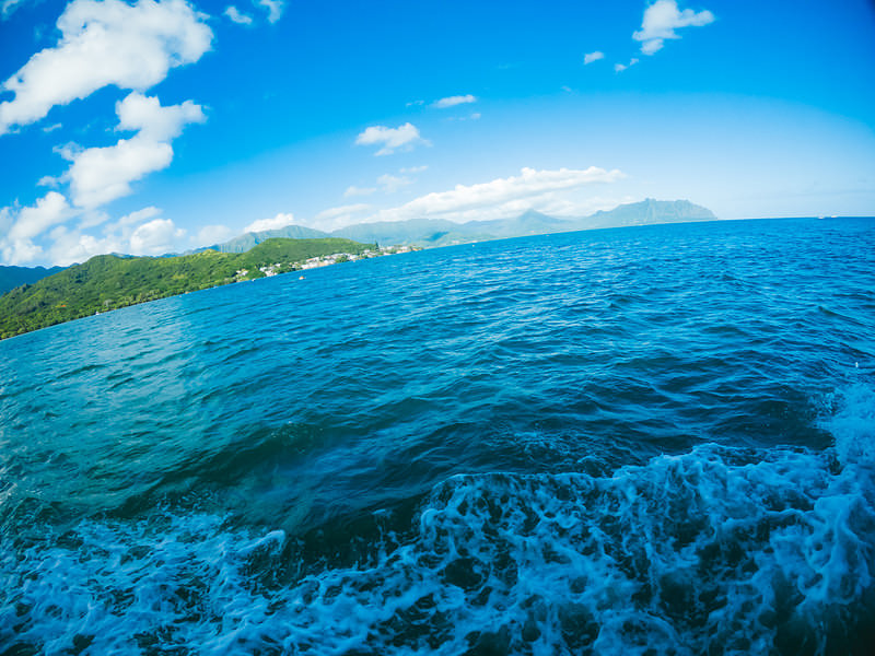ハワイの透明な海上を移動中の景色と島々