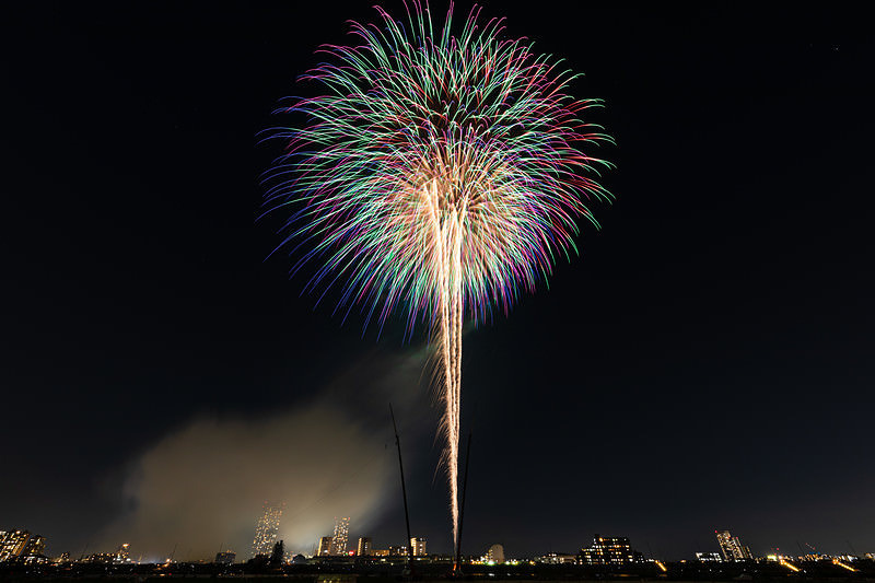 '風が吹いて少しだけ光跡が流れる打上花火'