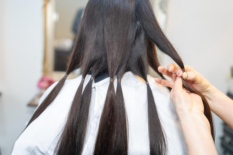 'ヘアドネーションカット前の髪束分けシーン'