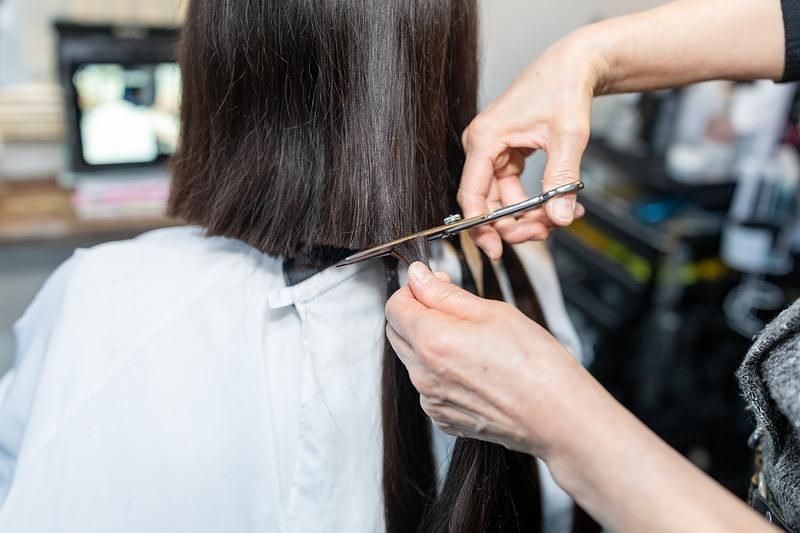 '寄付する髪の毛をカットする美容師'