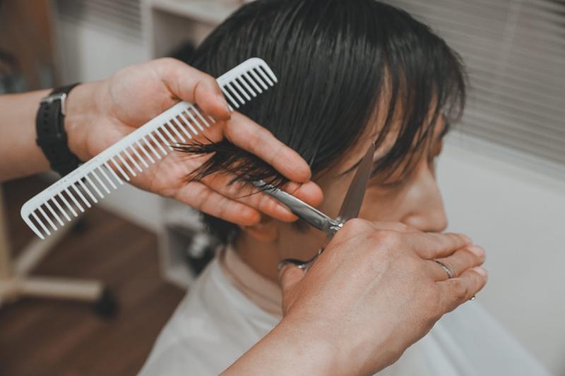'髪先をカットする美容師の手元'